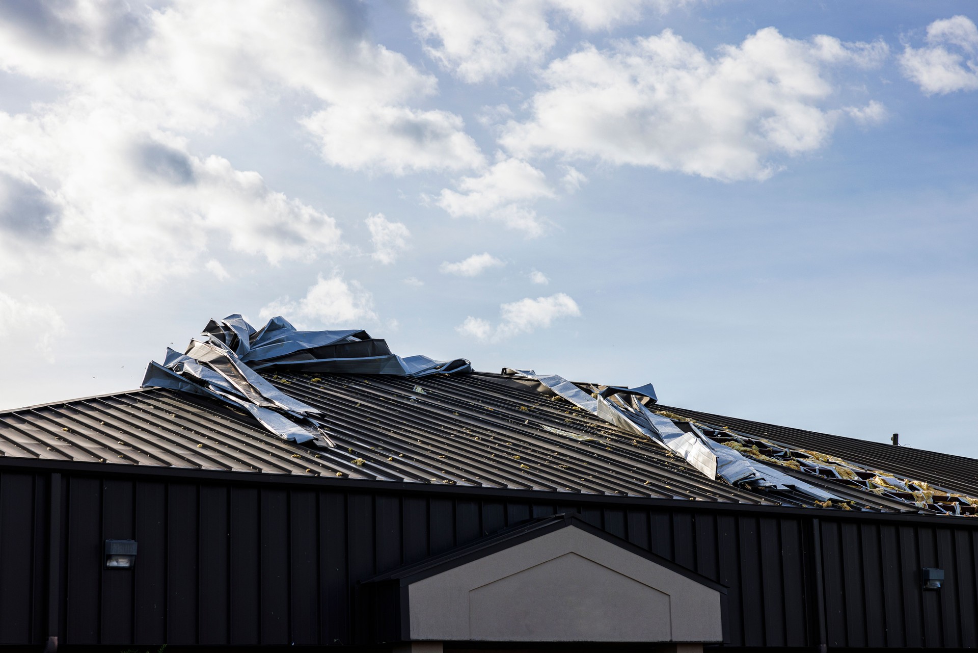 Damaged house roof, twisted shingle in residential area. Hurricane aftermath in small town Perry, North Florida